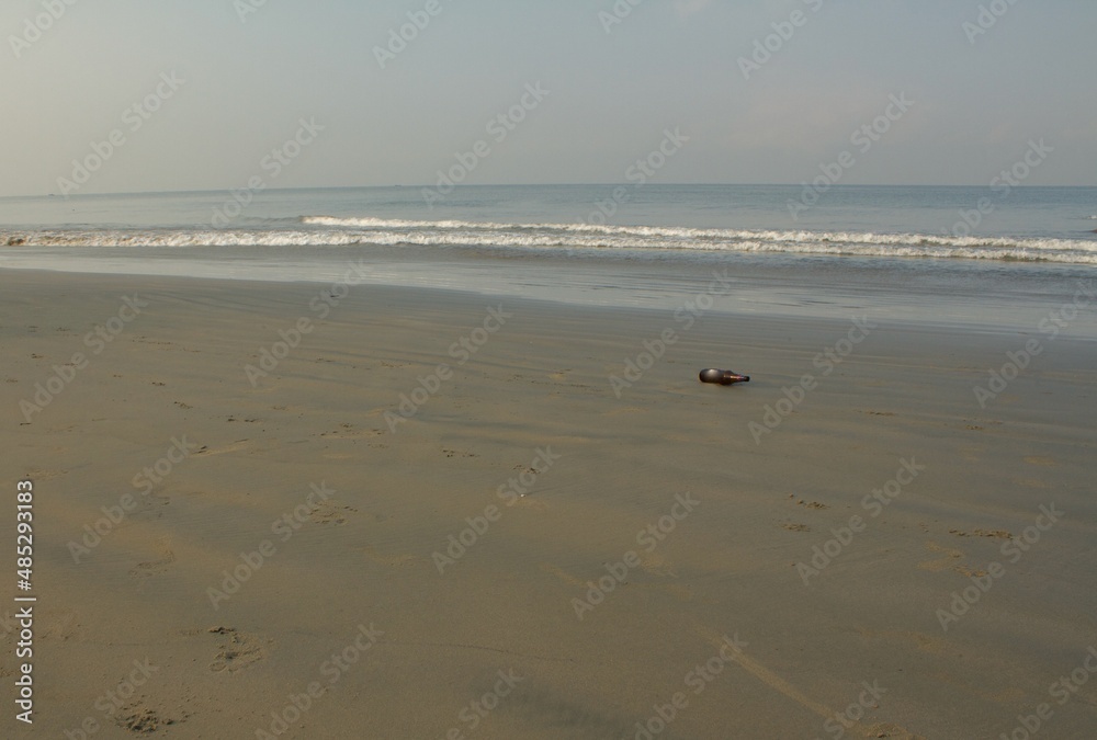 view from the sandy beach with a bottle in the foreground view from the sandy beach with a bottle in the foreground