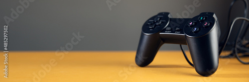 black game controller isolated on yellow background