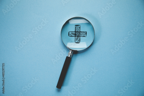 Magnifying glass with medical cross