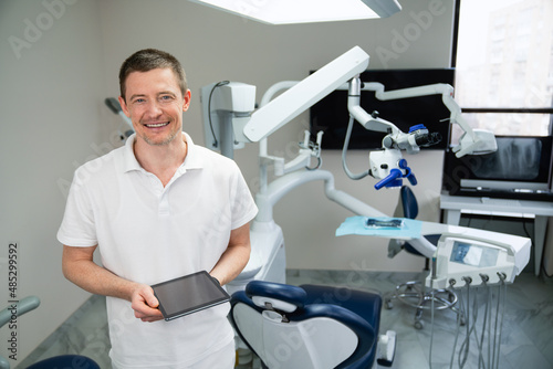Dentist with digital tablet in dental office