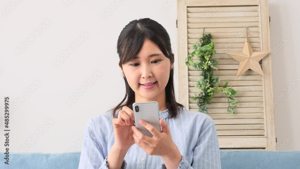 女性　スマホ　笑顔　リビング
