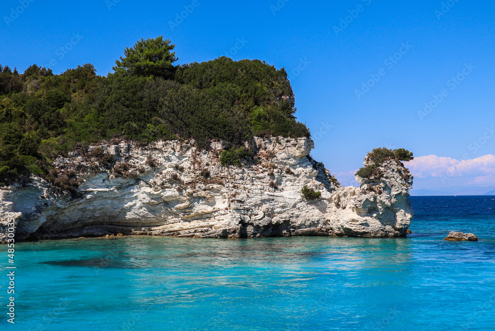 Rocky Stone in Turquoise Water with Blue Sky in Greece. Summer Day in Antipaxos with Ionian Sea.
