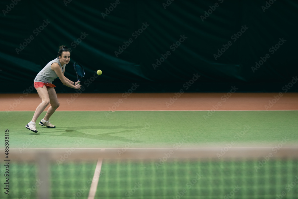 Tennis woman player playing training with racket and ball at court.