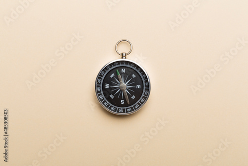 Silver compass on color background. Top view photo