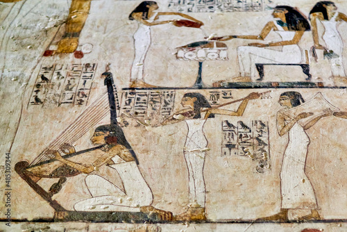 Colorful painting from and Ancient Egyptian tomb depicting female musicians, the first performing on a harp