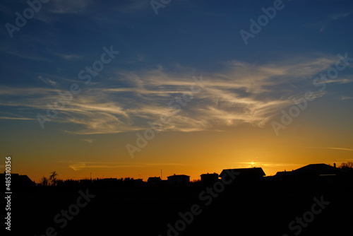 sunset over the city with blue and yellow colors and silver cloud