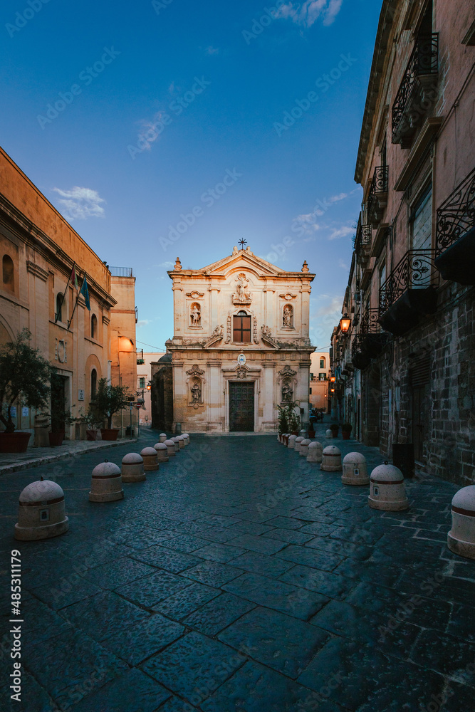 Wide view of the Cathedral of San Cataldo in the old town of Taranto at sunrise with person, vertical
