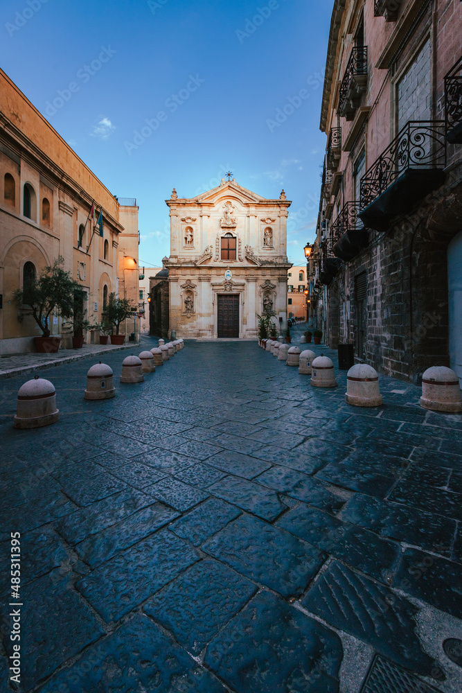 Wide view of the Cathedral of San Cataldo in the old town of Taranto at sunrise with person, vertical
