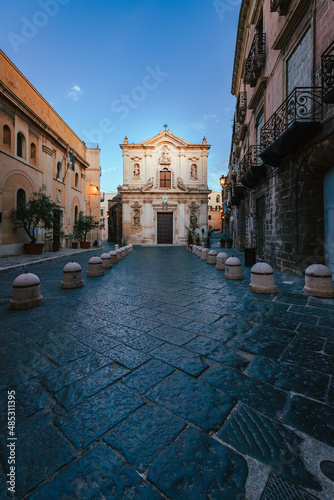 Fototapeta Naklejka Na Ścianę i Meble -  Wide view of the Cathedral of San Cataldo in the old town of Taranto at sunrise with person, vertical