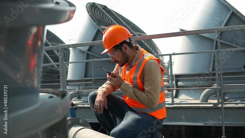 Engineer under checking the industry cooling tower air conditioner is water cooling tower air chiller HVAC of large industrial building to control air system.