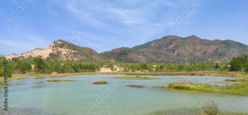 Natural scene including trees, lakes and sand and rocks with many colors