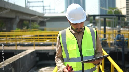 construction worker on site. service engineer  checking on waste water treatment plant with pump on background. worker  working on Waste water plant.
