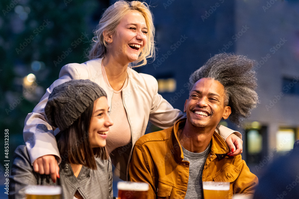 young blonde woman smiling and embracing her friends, multiracial people having fun at beer pub, social gathering and youth culture