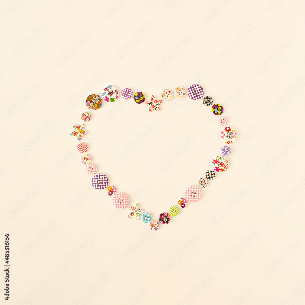 Heart shaped made of colorful buttons on white bright background. Valentine's day or Mothers' day concept.