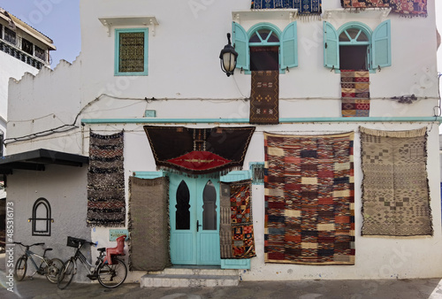 Bike parked next to a handmade carpets store in Assilah © Mounir