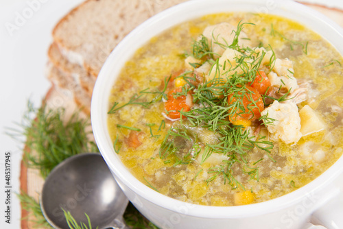 Vegetable and chicken soup with decorated with dill, served with fresh bread