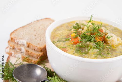 Vegetable and chicken soup with decorated with dill, served with fresh bread