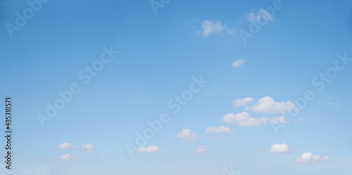 Fototapeta Naklejka Na Ścianę i Meble -  light blue sky background with some floatiing single cumulus clouds at the bottom half