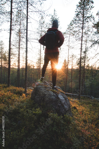 explorer looks out and explores new areas in the Kainuu region, in the middle of Finland. Searching for new targets and views in a forested environment. Reaching the destination at sunset photo