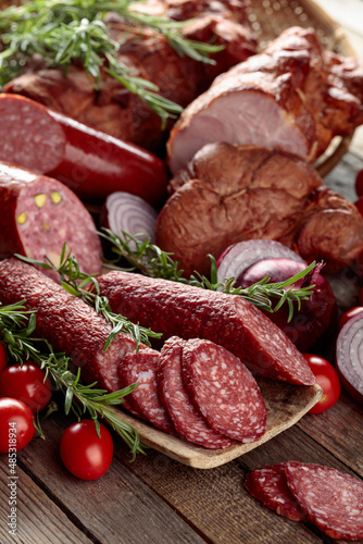 Various meat products on a wooden table.