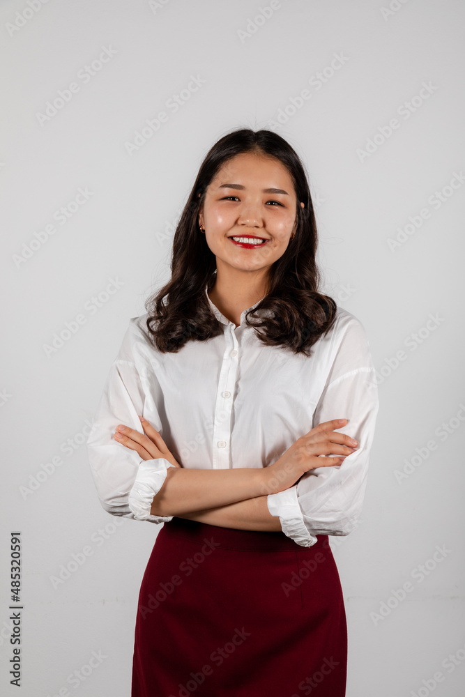 Portrait of smiling young asian woman with crossed hands on a white background Portrait of smiling young asian woman with crossed hands on a white background