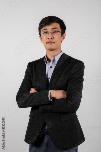 Portrait of young asian man wearing glasses, black office jacket and blue shirt