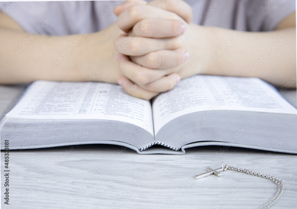 Christian faith. Reading the bible. Hands praying to God with a Bible. Beg for forgiveness and believe in goodness. Concept for faith, spirituality and religion. Christian faith. Reading the bible. Hands praying to God with a Bible. Beg for forgiveness and believe in goodness. Concept for faith, spirituality and religion.