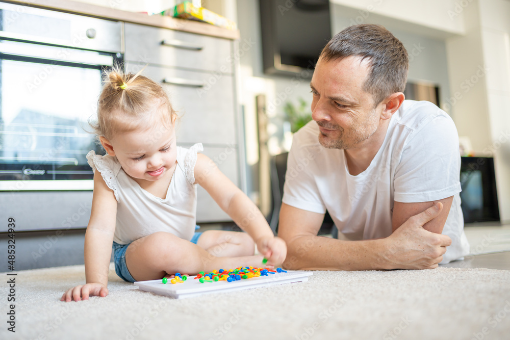 Cute little girl playing with mushroom nail mosaic. Father and baby playing together concept. Hobby and leisure time. Cute little girl playing with mushroom nail mosaic. Father and baby playing together concept. Hobby and leisure time.