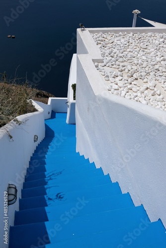 May 7, 2021 : A door and steps leading to a residential building with a beautiful view on the Aegean Sea and the volcano of Santorini in Greece © DIMITRIOS