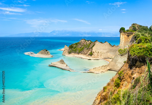 Cape Drastis cliffs near Sidari and Peroulades on Corfu island in Greece. Famous rock formations with small beach and rugged coastline. Popular Greek destination for summer vacation. photo