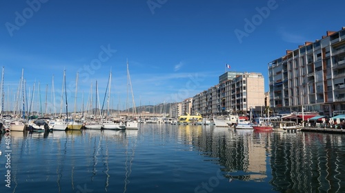 Port de pêche et de plaisance de la ville de Toulon, avec des bateaux se reflétant dans l’eau bleue de la mer Méditerranée (France)