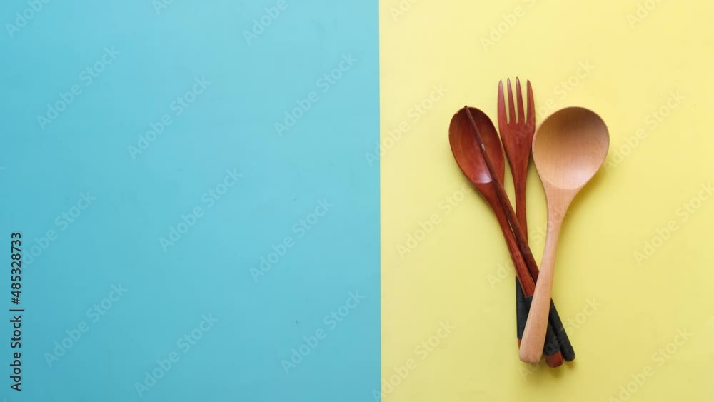 putting wooden cutlery forks on light yellow background putting wooden cutlery forks on light yellow background