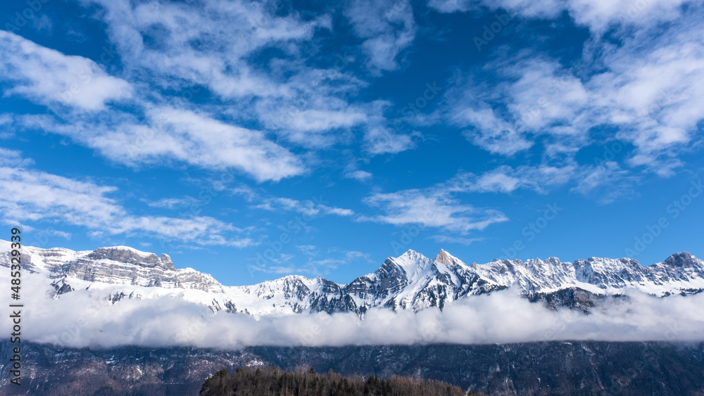 Eindrückliche Bergkette bei Flums in der Schweiz mit blauem Himmel und Wolken.