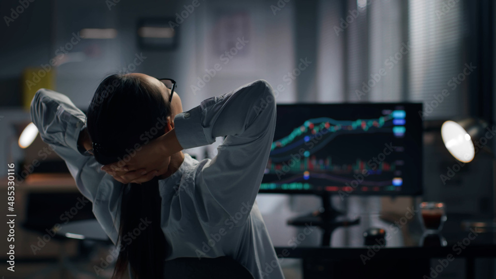 Rear view of successful broker relax on chair with hands behind her head. Rear view of successful broker relax on chair with hands behind her head.