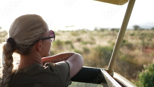 Africa Safari wildlife view Blonde lady Woman girl from a car jeep drive on a safari adventure trip in Masai Mara park Kenya savana tsavo west tanzania