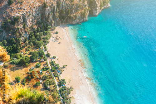 Fototapeta Naklejka Na Ścianę i Meble -  Spectacular view of white sand beach and turquoise sea of Butterfly Valley. Butterfly Valley (Turkish: Kelebekler Vadisi) is a valley in Fethiye district of Mugla Province, Turkey.