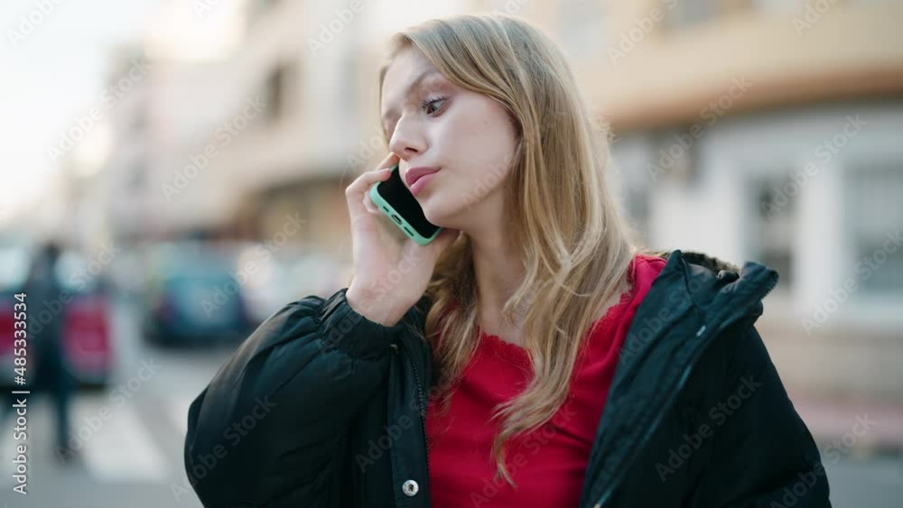 Young blonde girl smiling confident talking on the smartphone at street Young blonde girl smiling confident talking on the smartphone at street