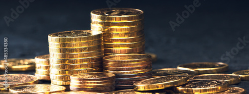 A stack of gold coins isolated on a black background.Money on a black background.Finance and money. Banner.
