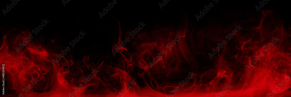 Abstract colored smoke moves on black background. Mystical swirling smoke rolling low across the ground.