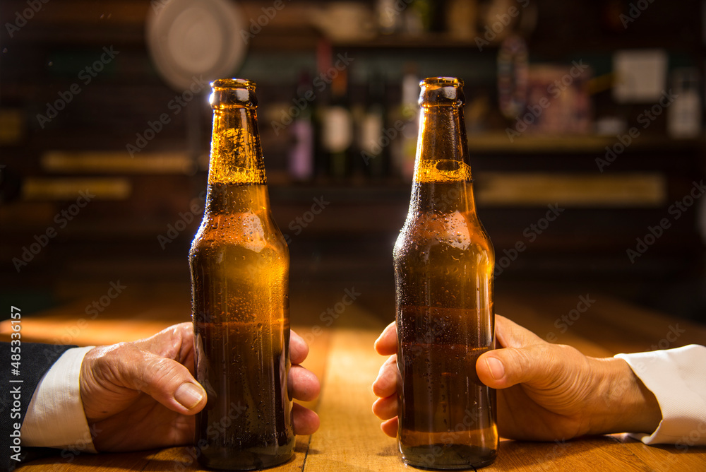 hand holding beer bottle in bar