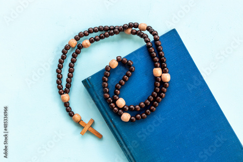 Old Bible book and rosary beads with cross. Christian religion concept