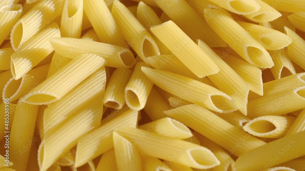 Rotating uncooked pasta . Stack of traditional dry raw macaroni. Nobody Rotating uncooked pasta . Stack of traditional dry raw macaroni. Nobody
