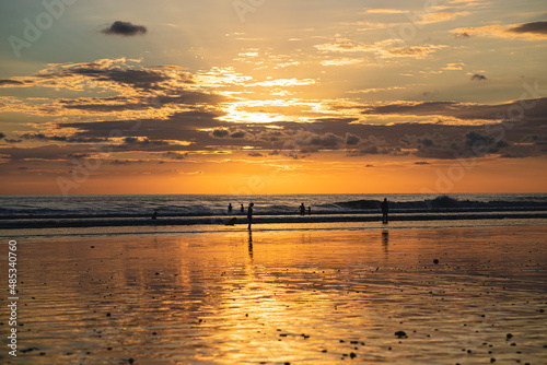 beautiful sunset on a beach in costa rica with unrecognizable people silhouettes, Playa hermosa photo