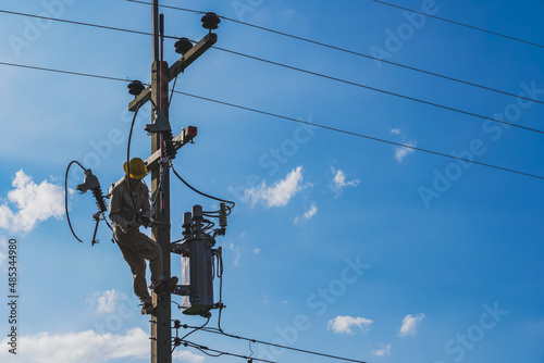 The silhouette of power lineman replacing a transformer and hotline clamp, bail  clamp. Using clamp stick grip all type, wearing personal protective equipmen,