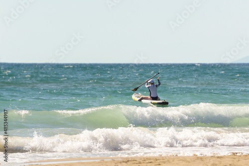 The girl is engaged in SUP-surfing, water sports.