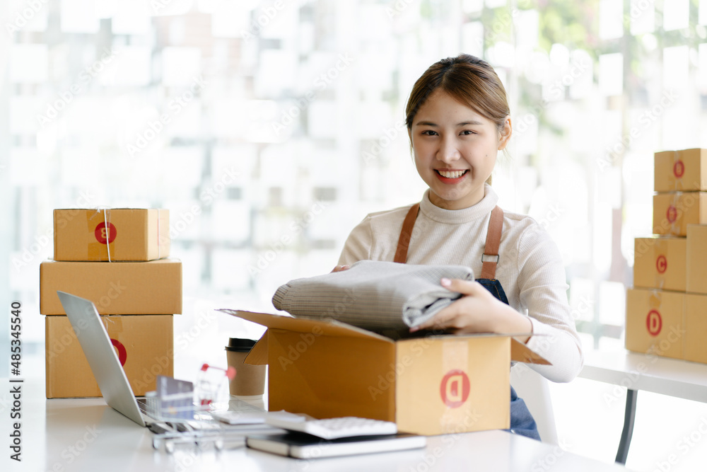 a manufacturing worker putting packed products, in cardboard boxes before export or shipping during manual work. a manufacturing worker putting packed products, in cardboard boxes before export or shipping during manual work.