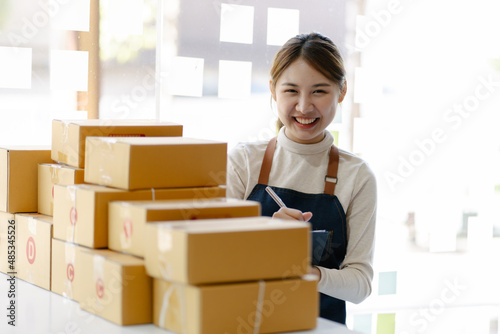 Smiling young woman preparing a package