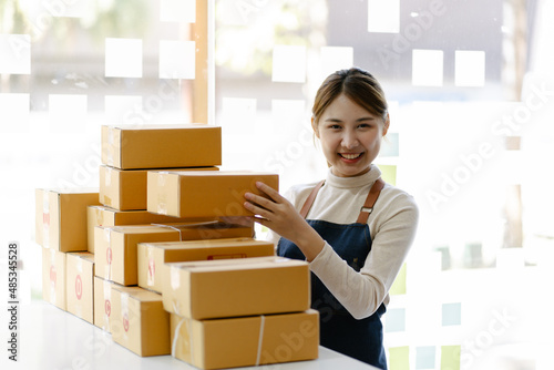 Professional Warehouse Worker Checks and Seales Cardboard Box Ready for Shipment. photo