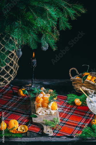 Sweet merengue roll with slices of tangerines. Delicious dessert decorated with orange fruits.