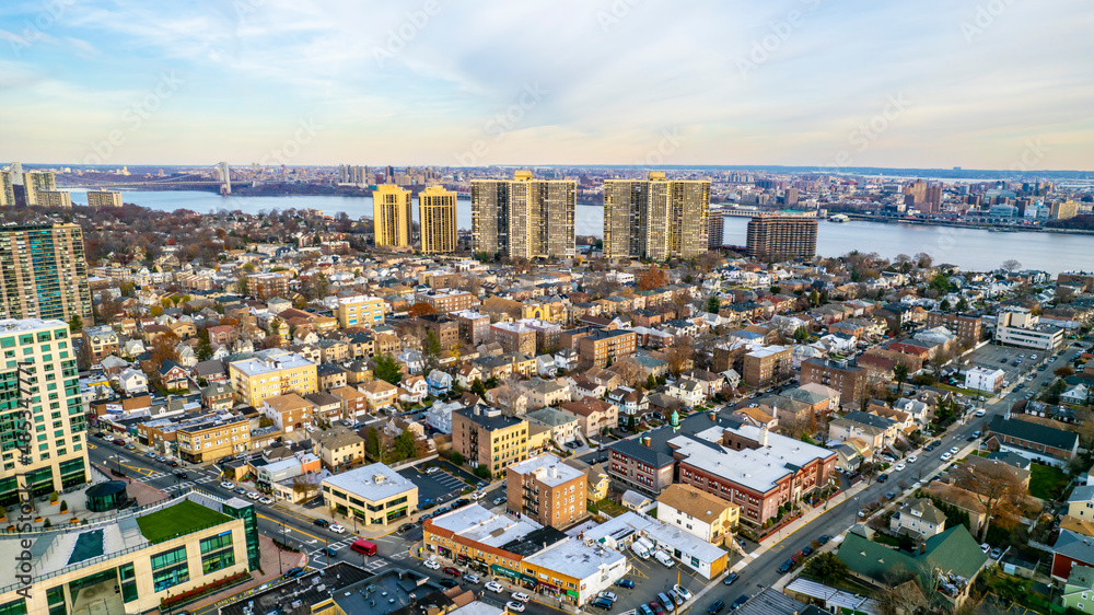 Obraz premium An aerial wide shot captures a coastal urban landscape featuring a mix of residential and high-rise commercial buildings in a metropolitan setting at dusk for city lifestyle promotion.